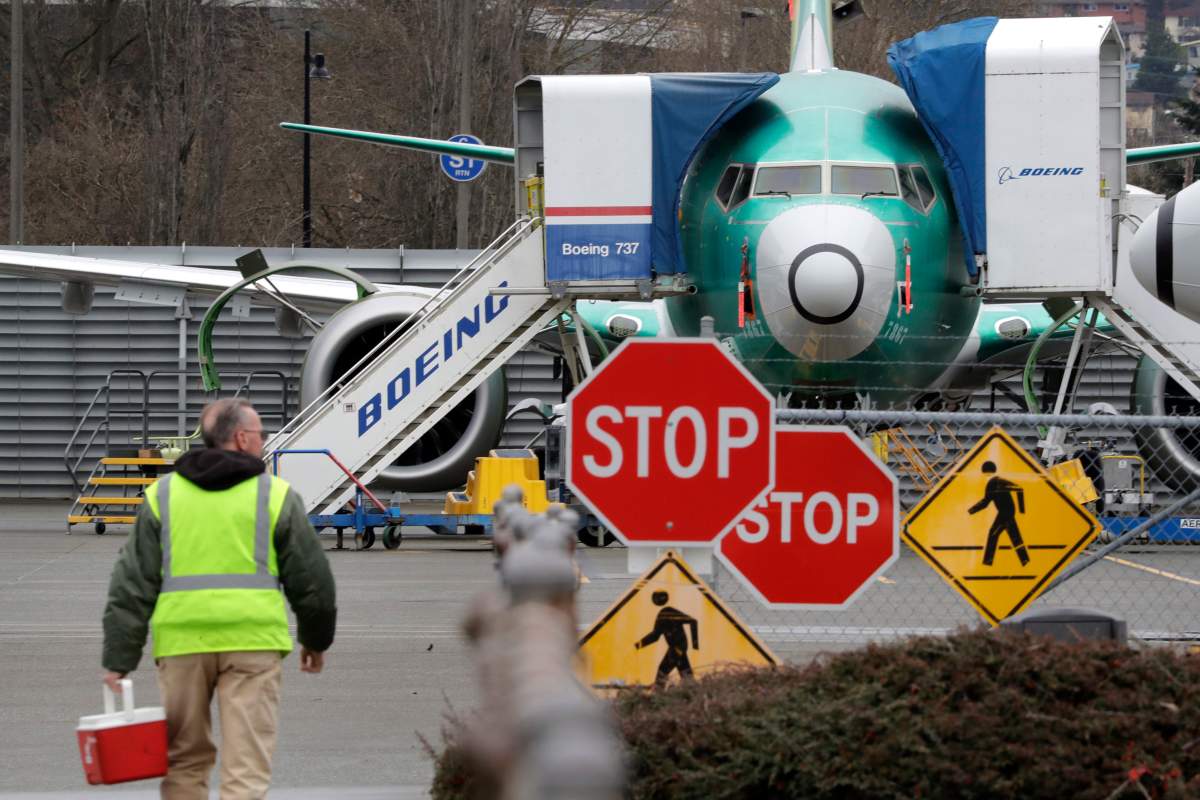 A Boeing worker walks in view of a 737 MAX jet Dec. 16, 2019, in Renton, Wash.
