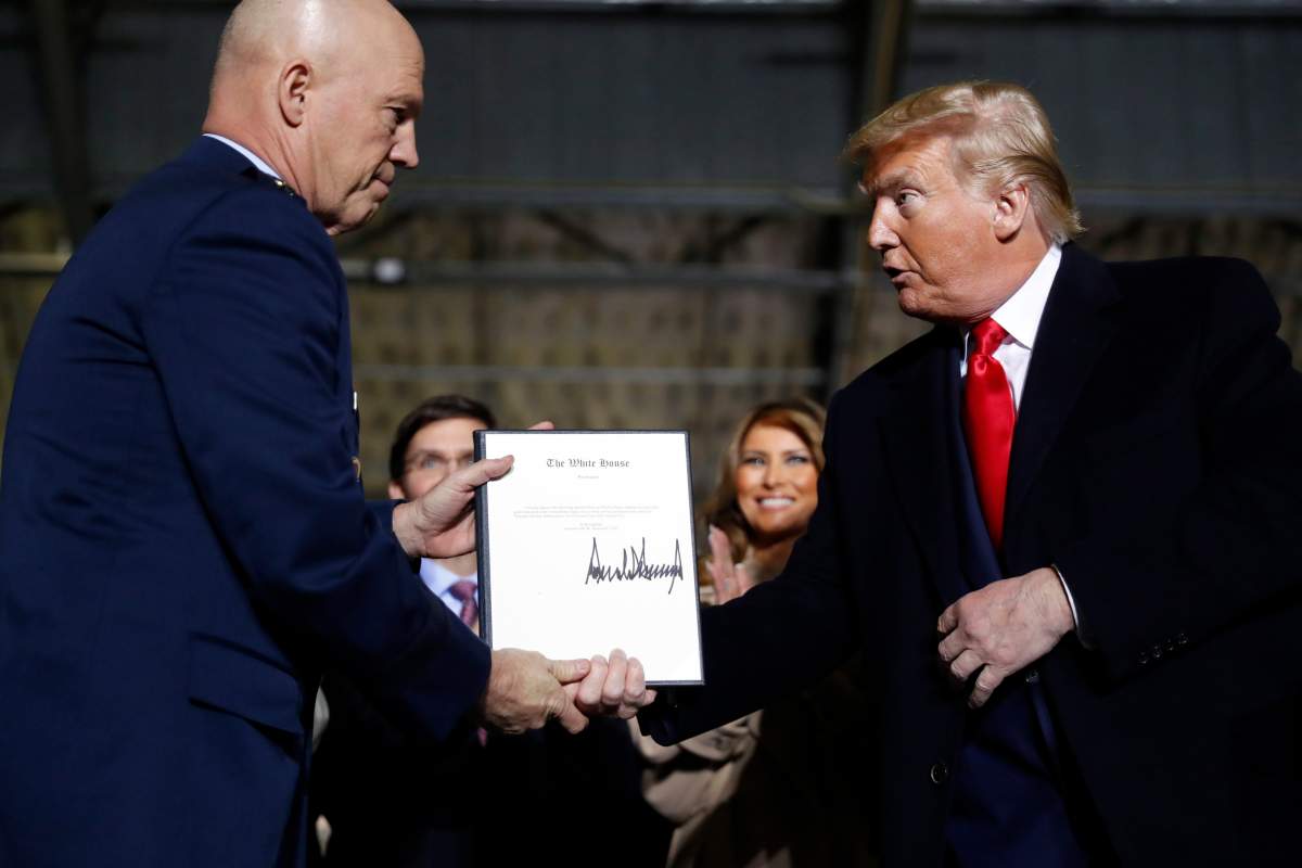 President Donald Trump shakes hands with Gen. Jay Raymond, after signing the letter of his appointment as the chief of space operations for U.S. Space Command at Andrews Air Force Base, Md., Dec. 20, 2019.