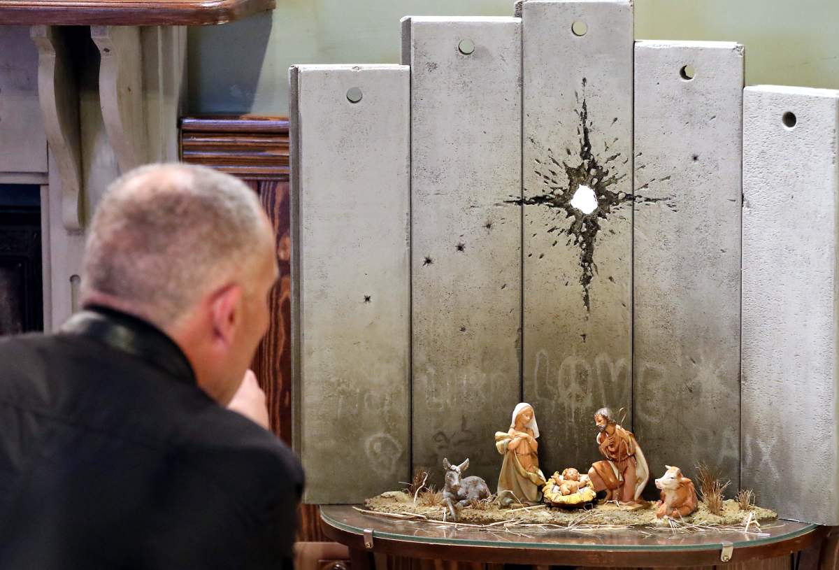 A view of a new artwork by elusive British graffiti artist Banksy depicting the nativity scene dubbed ‘Scar of Bethlehem’, displayed in the Walled Off hotel, in the West Bank city of Bethlehem, Dec. 22, 2019.