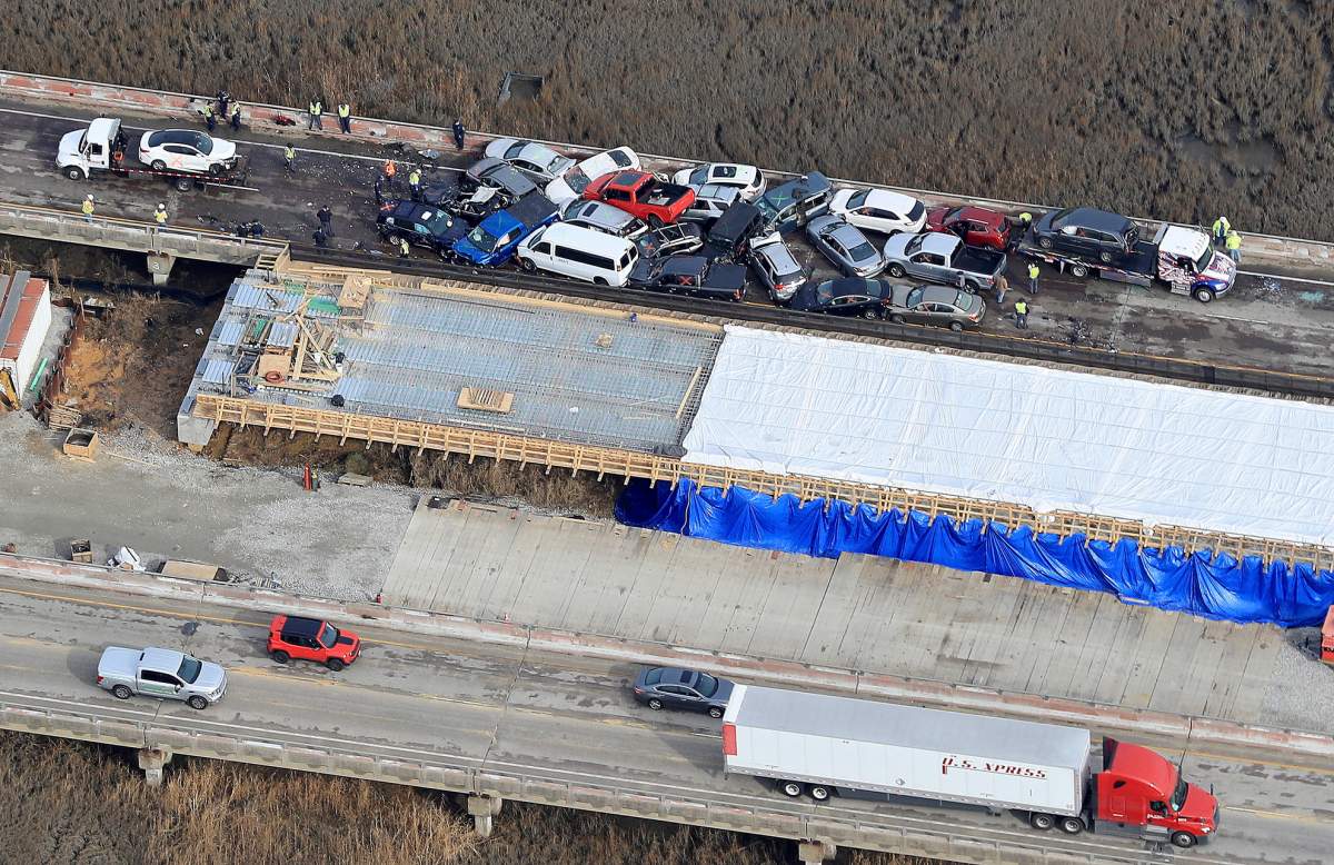 Crews work to clear vehicles from the Queens Creek overpass on I-64 in York County, Va., Sunday December 22, 2019 after a chain-reaction crash involving multiple vehicles.