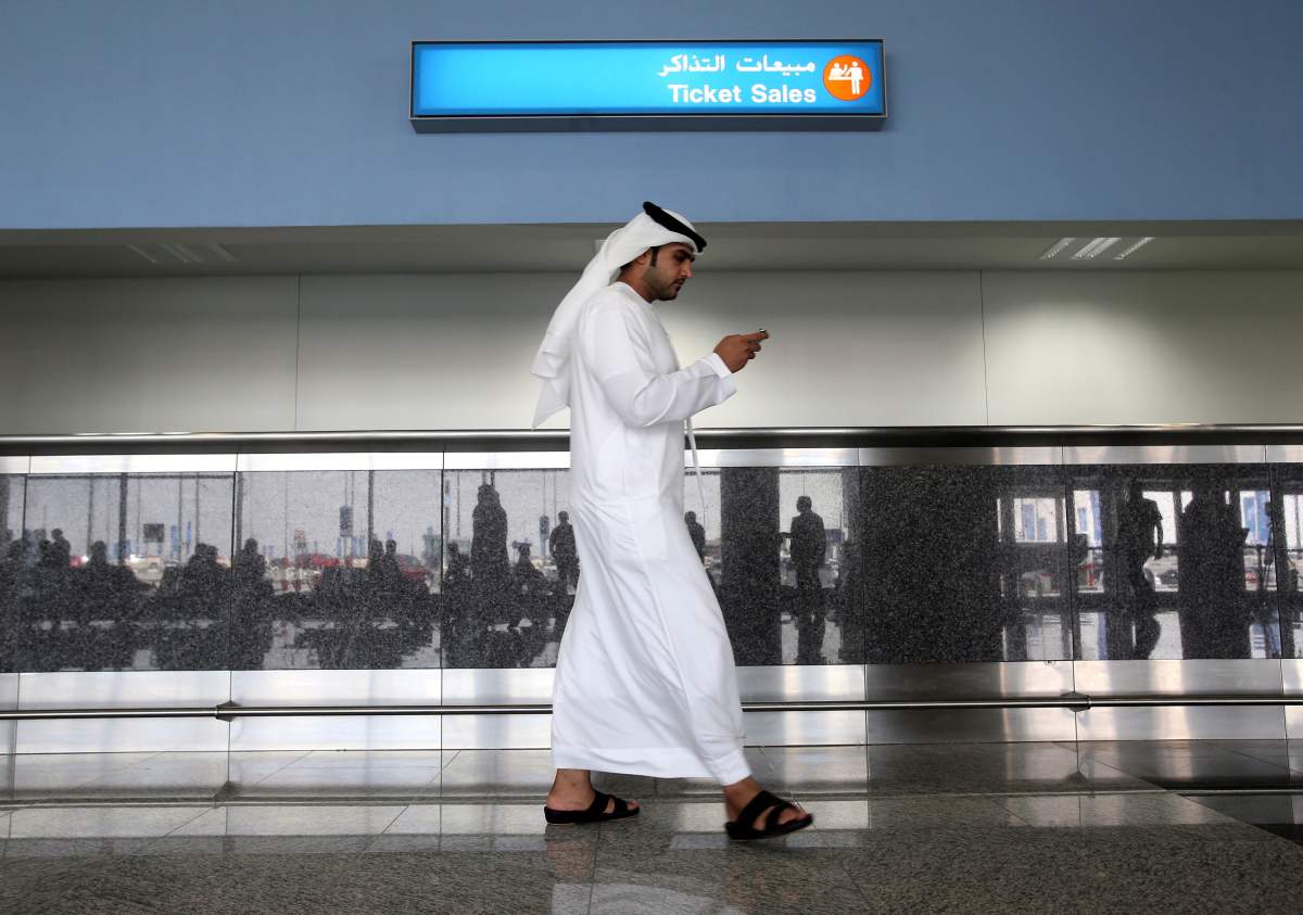  In this Oct. 27, 2013 file photo, a worker looks at his mobile phone at the newly opened Al Maktoum International Airport in Dubai, United Arab Emirates. 
