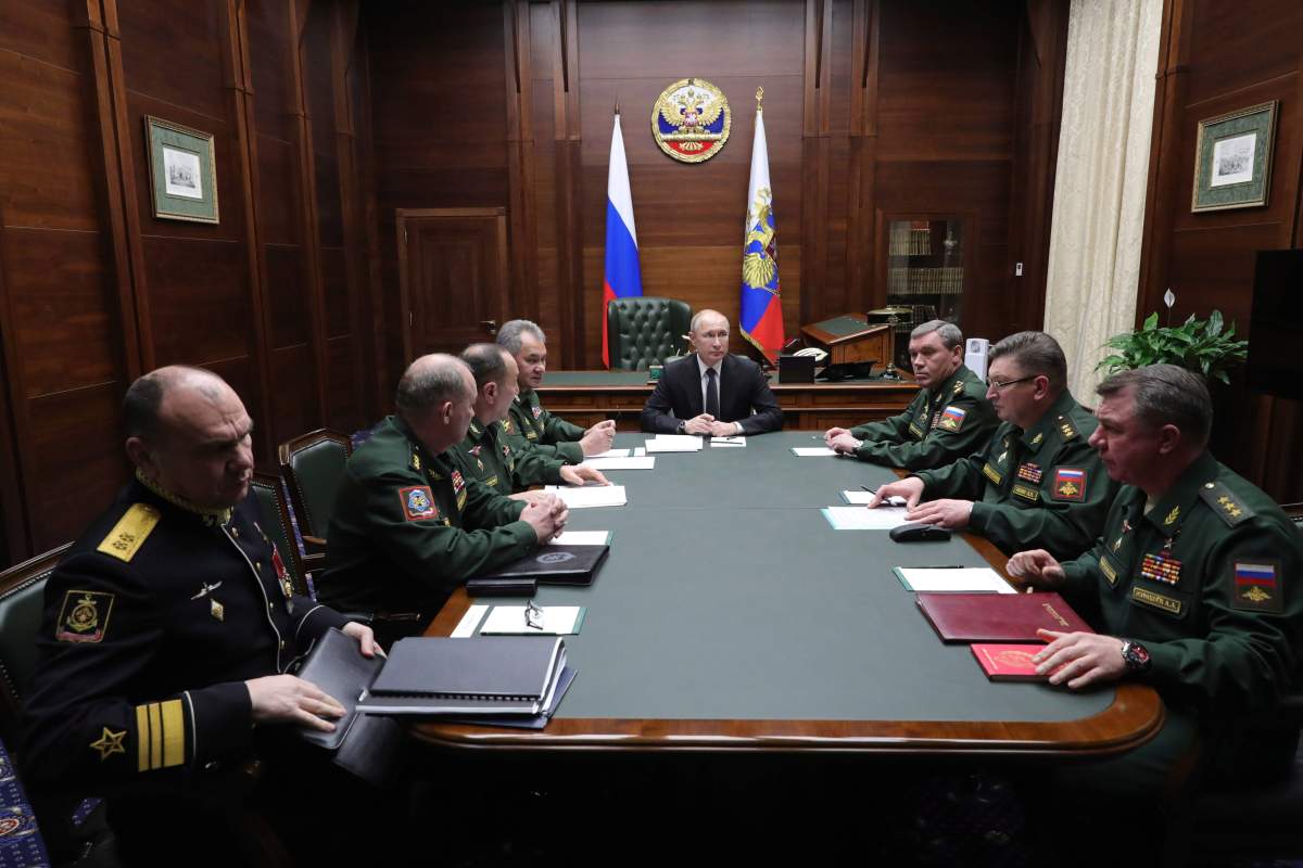Russian President Vladimir Putin, center, leads a meeting with top military officers after an annual meeting with top military officials in the National Defense Control Center in Moscow, Russia, Tuesday, Dec. 24, 2019. 