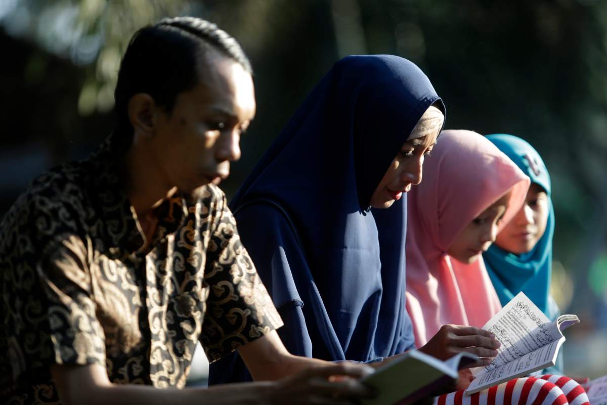 Tsunami survivors pray for their relatives at the Siron Mass Grave in Banda Aceh, Indonesia, 26 December 2019.