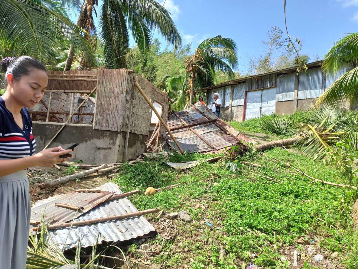 A villager stand next to a damaged home in the typhoon-hit town of Balasan, Ilo-Ilo province, Philippines, 26 December 2019.