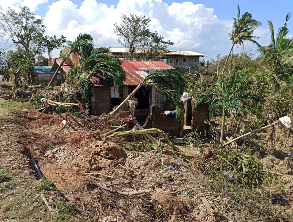 Toppled coconut trees rest on top of a home in the typhoon-hit town of Balasan, Ilo-Ilo province, Philippines, 26 December 2019.