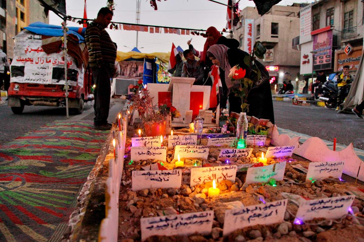 People light candles for protesters who have been killed in anti-government demonstrations in Tahrir Square in Baghdad, Iraq, Thursday, Dec. 26, 2019.