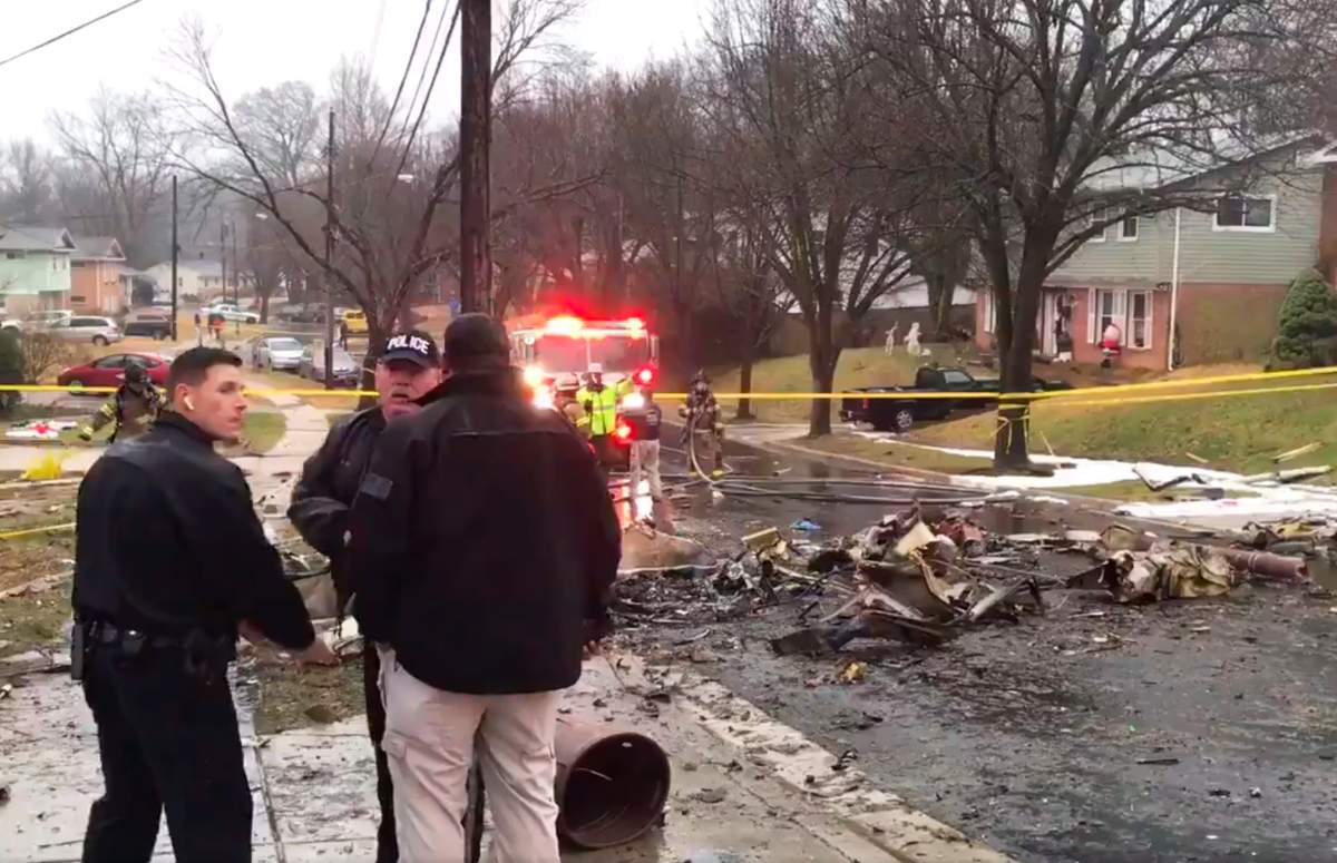 In this image made from video provided by the Prince George’s County Fire and Emergency Medical Services Department, firefighters and police officers investigate the scene of a small plane crash in the Lanham neighbourhood, Md., Dec. 29, 2019.