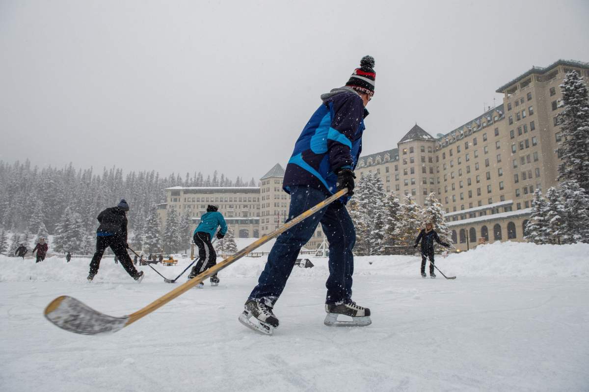 Hockey players skate behind the Chateau Lake Louise on Lake Louise, Alta., Wednesday, Dec. 4, 2019.