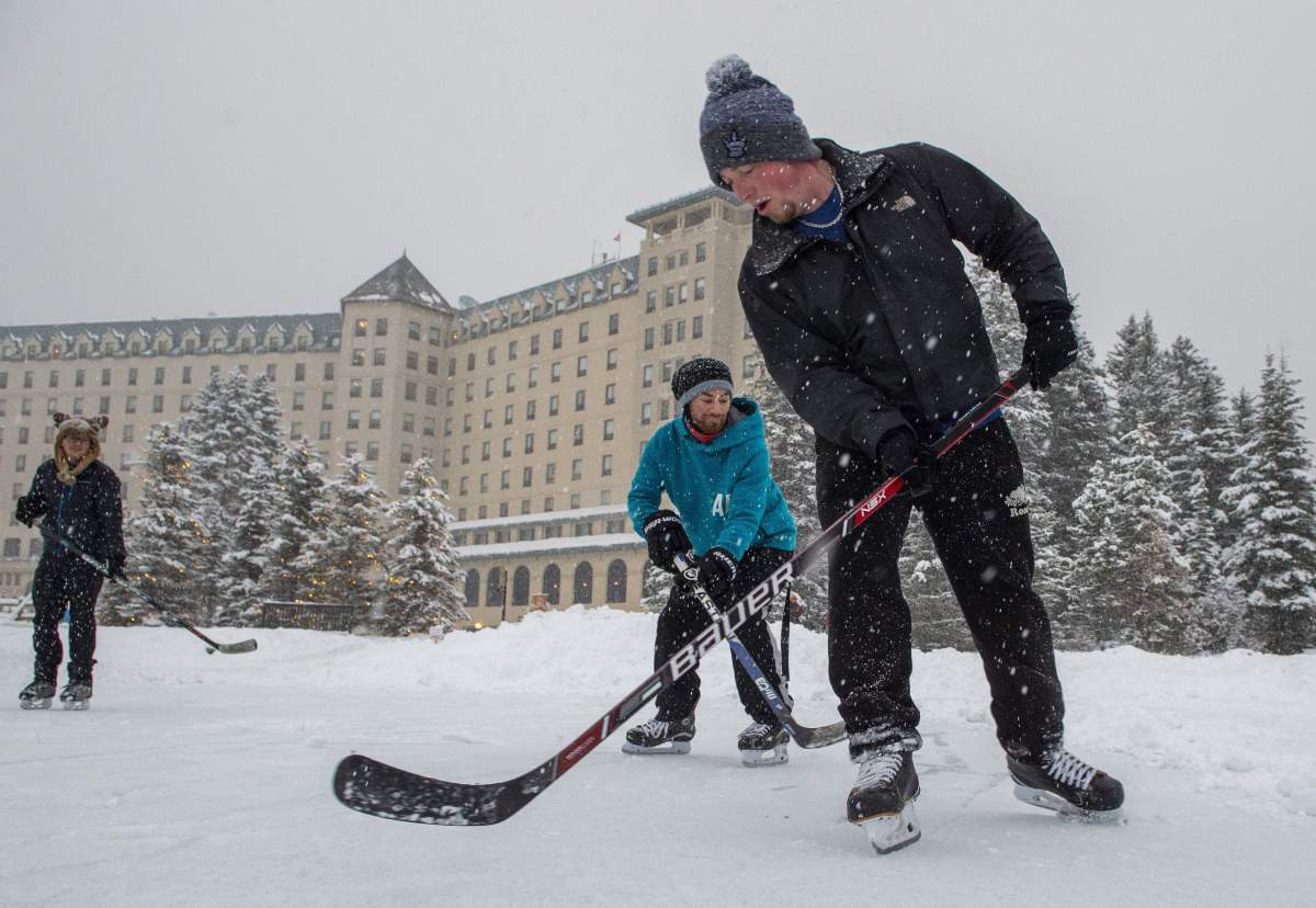 Hockey players skate behind the Chateau Lake Louise on Lake Louise, Alta., Wednesday, Dec. 4, 2019.