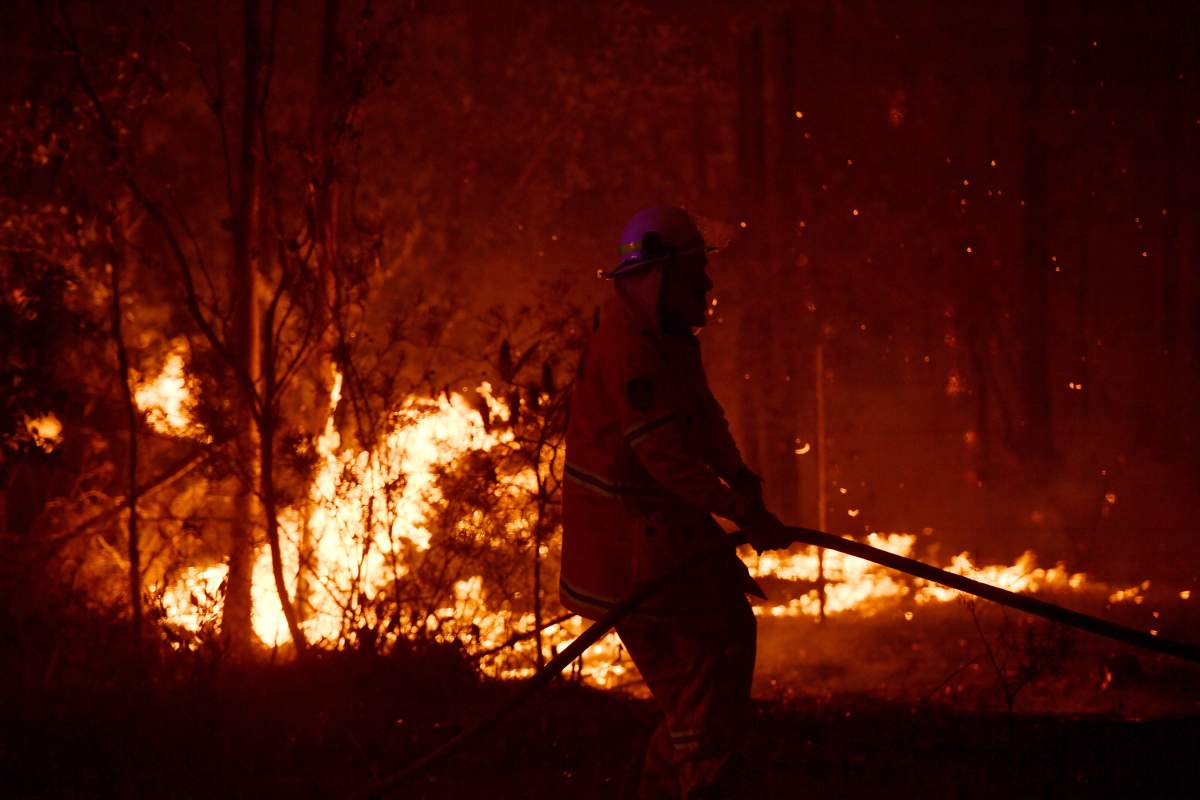 A Rural Fire Service (RFS) firefighter conducts mopping up near the town of Sussex Inlet on December 31, 2019 in Sydney, Australia.