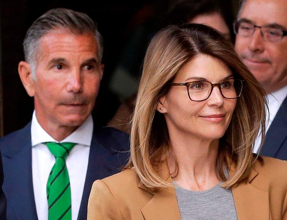 Actress Lori Loughlin, front, and her husband, clothing designer Mossimo Giannulli, left, depart federal court in Boston after facing charges in a nationwide college admissions bribery scandal.