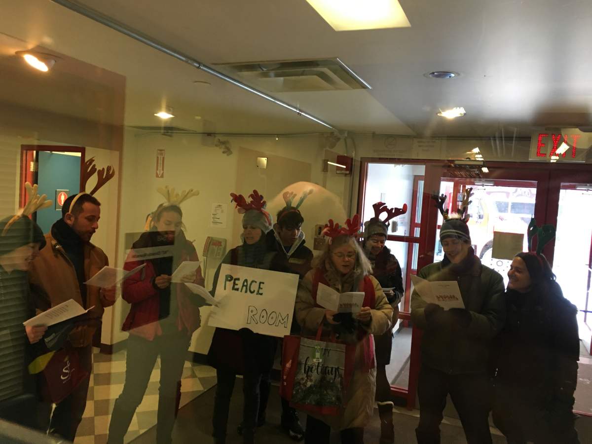 Carol-singing protesters are seen outside the launch of the Canadian Energy Centre, also known as Alberta’s war room, on Wednesday. Dec. 11.