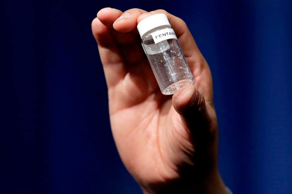 A reporter holds up an example of the amount of fentanyl that can be deadly after a news conference about deaths from fentanyl exposure, at DEA Headquarters in Arlington, Va., Tuesday, June 6, 2017.