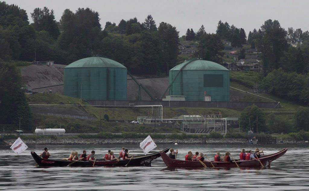 Canoeists paddle first nation canoes past the Kinder Morgan facility in Burrard Inlet in North Vancouver, B.C. Thursday, May, 22, 2014.Four British Columbia Indigenous groups are set to argue in the Federal Court of Appeal that the Canadian government failed to consult adequately with them before its latest approval of the Trans Mountain pipeline expansion. THE CANADIAN PRESS/Jonathan Hayward.