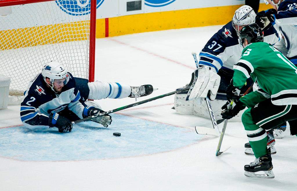 Winnipeg Jets defenseman Anthony Bitetto (2) prevents Dallas Stars forward Blake Comeau (15) from scoring a goal during the first period of an NHL hockey game Thursday, Dec. 5, 2019, in Dallas. (AP Photo/Brandon Wade)