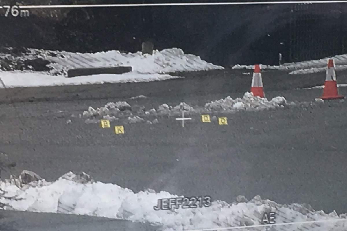 Evidence markers in the street seen through the viewfinder of a camera.