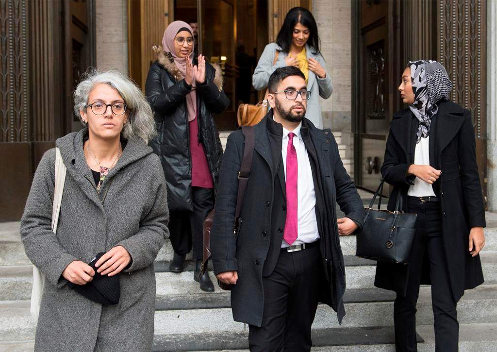 Members of the National Council of Muslims Mustafa Farooq, centre, and Bochra Manai, left, alongside supporters leave the Quebec Court of Appeal in Montreal, Tuesday, Nov. 26, 2019, where they are challenging Quebec's Bill 21.