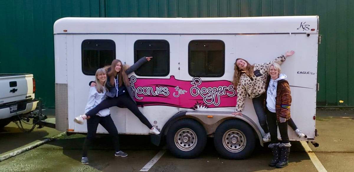 Rona Doucette (far right), Tamara Meggitt (far left) and two international students pose in front of a trailer loaded with donated goods for the families of striking loggers.