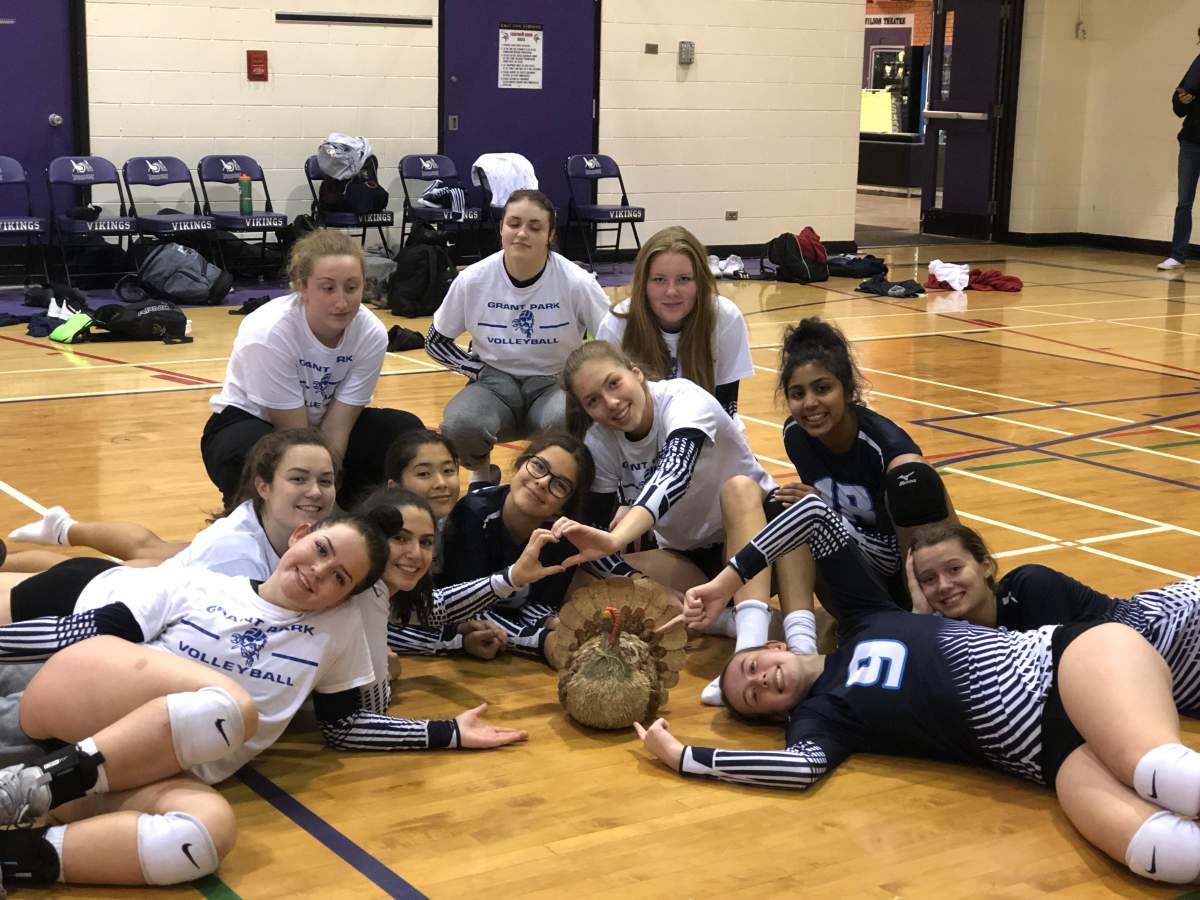 The Grant Park girls varsity volleyball team posing with “Kingston” the turkey.