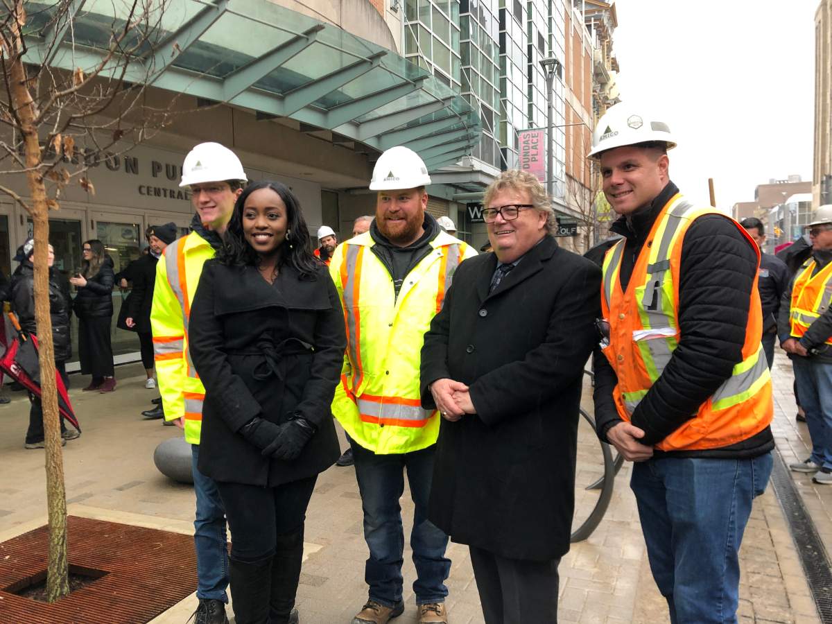 Councillor Arielle Kayabaga and Mayor Ed Holder with constriction workers at bricklaying ceremony on Dundas Place. 