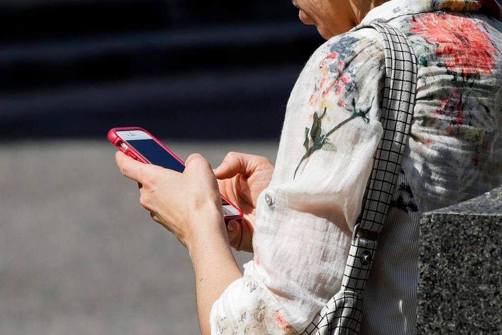 FILE - In this April 8, 2019, file photo, a woman browses her smartphone in Philadelphia. (AP Photo/Matt Rourke, File).