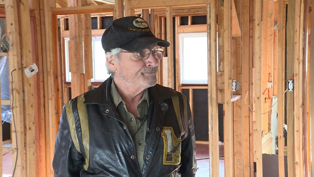 Reg Dionne stands in his gutted home
