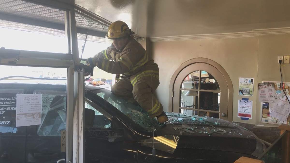 Firefighters work to remove a pickup truck which crashed into the front of Vito's restaurant in Brighton Friday morning.