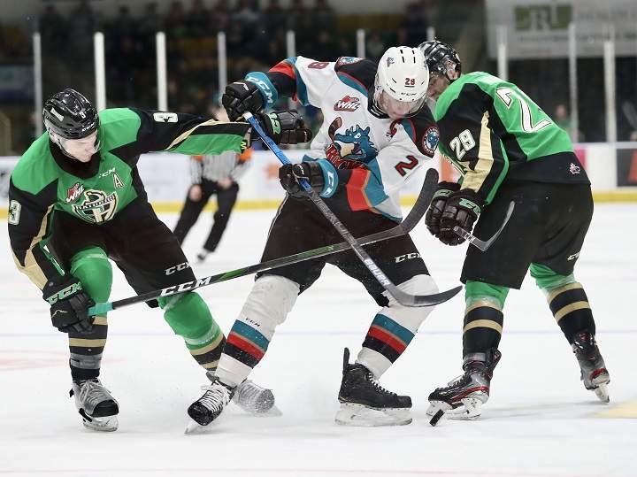 Nolan Foote of the Kelowna Rockets, middle, vies for the puck between Prince Albert defenceman Jeremy Masella, left, and left winger Justin Nachbaur, right, during WHL action on Friday, Dec. 6, 2019. The Saskatchewan government said the province’s WHL teams and the SJHL need funding in order to survive the challenges they face due to the COVID-19 pandemic.