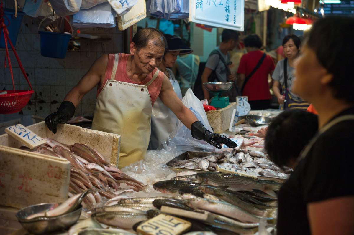 A fishmonger arranges fish for sale in a wet market in Hong Kong, China, 19 July 2016.