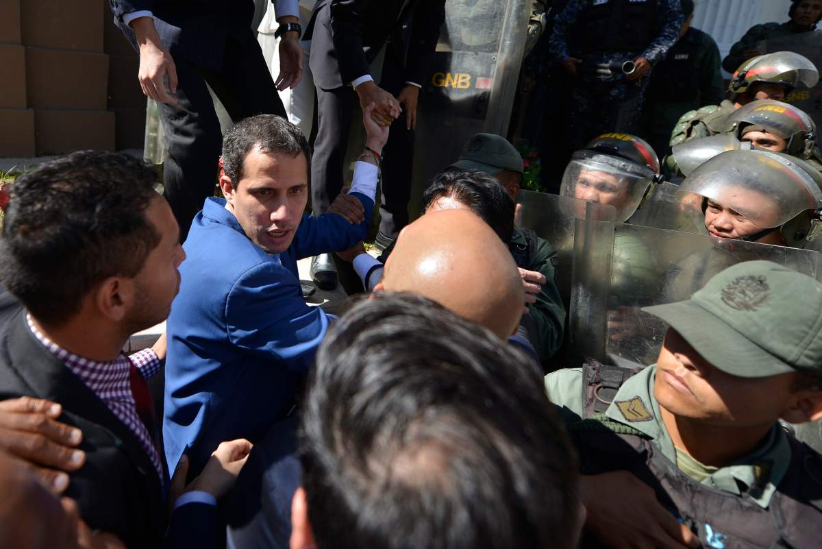 National Assembly President Juan Guaido tries to entry at the National Assembly as he and other opposition lawmakers are blocked by police from entering a session to elect new Assembly leadership in Caracas, Venezuela, Sunday, Jan. 5, 2020.