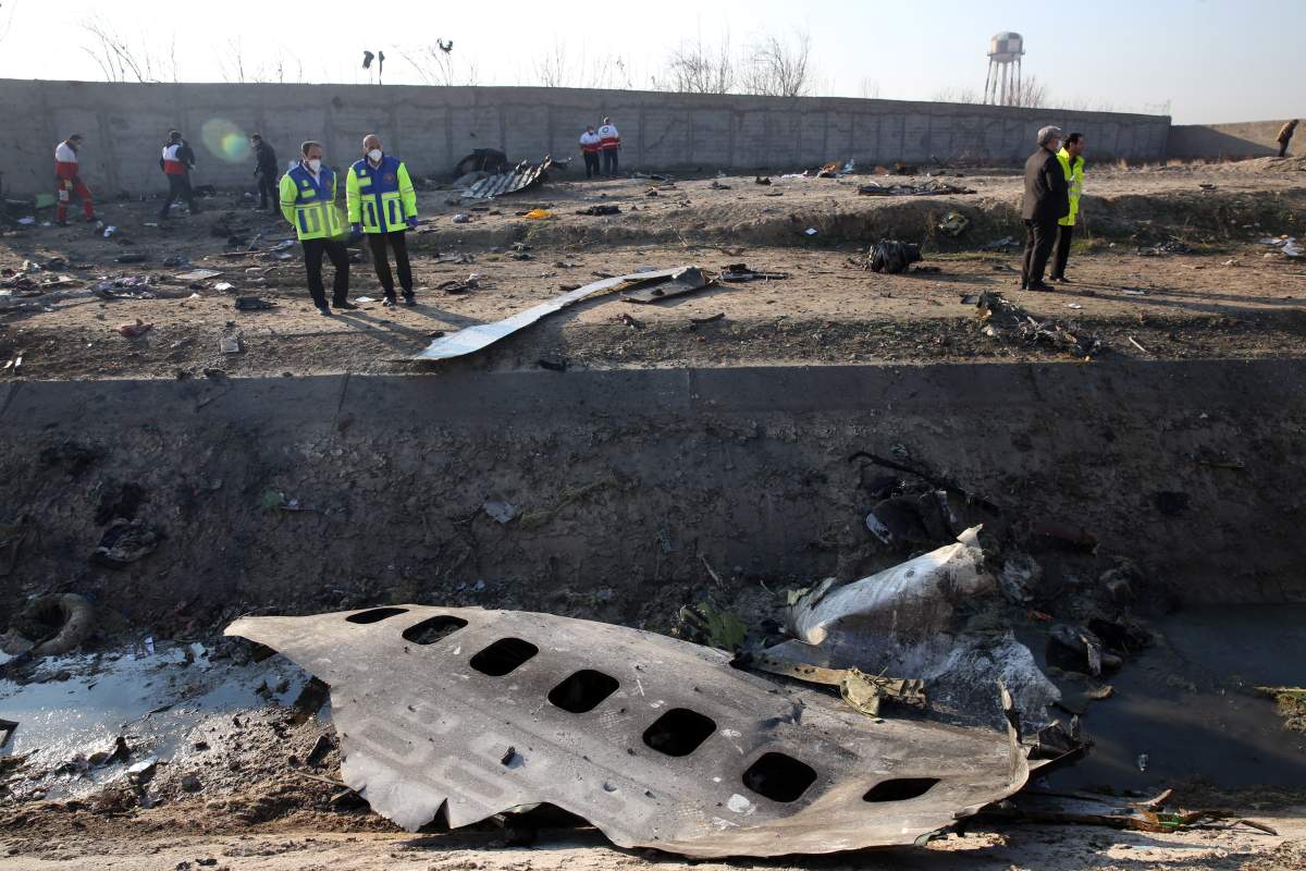 Officials stand near the wreckage after an Ukraine International Airlines Boeing 737-800 carrying 176 people crashed near Imam Khomeini Airport in Tehran, killing everyone on board; in Shahriar, Iran, 08 January 2020.