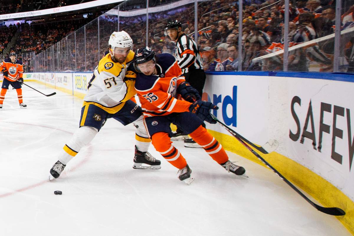 Nashville Predators' Dante Fabbro (57) and Edmonton Oilers' Kailer Yamamoto (56) battle for the puck during second period NHL action in Edmonton, Tuesday, Jan. 14, 2020. THE CANADIAN PRESS/Jason Franson.