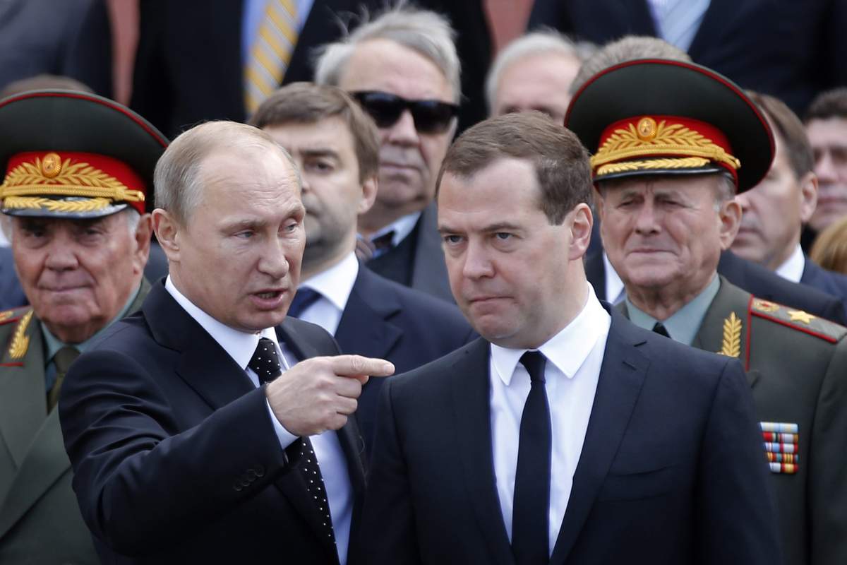 Russian President Vladimir Putin (C-L) speaks with Russian Prime Minister Dmitry Medvedev (C-R) at the 73rd anniversary of Nazi Germany’s invasion of the Soviet Union at the Tomb of the Unknown Soldier at the Kremlin walls in Moscow, Russia, June 22, 2014.
