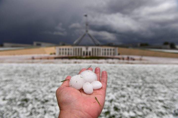 A man shows golf ball-sized hail outside Parliament House after a severe hailstorm hit Canberra, Australia, Jan. 20, 2020.