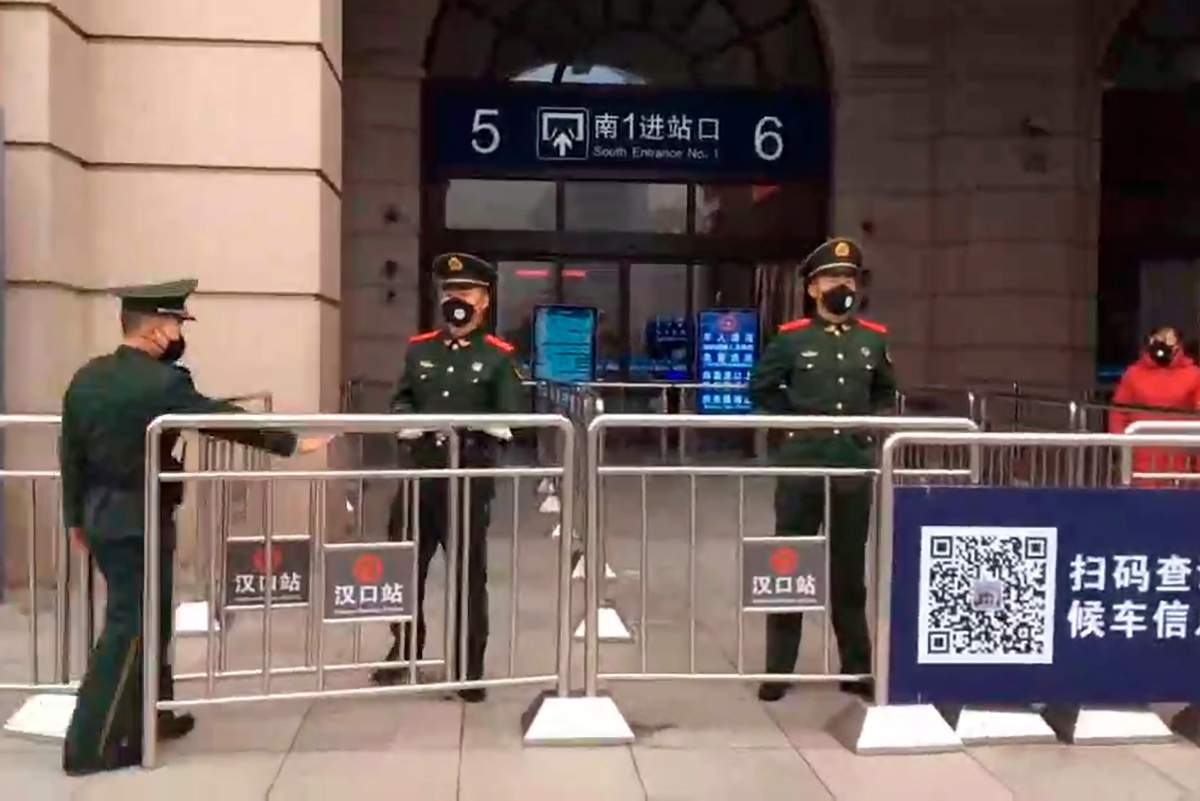 In this image made from video, Chinese paramilitary police stand guard outside the closed Hankou Railway Station in Wuhan in central China’s Hubei Province, Thursday, Jan. 23, 2020.