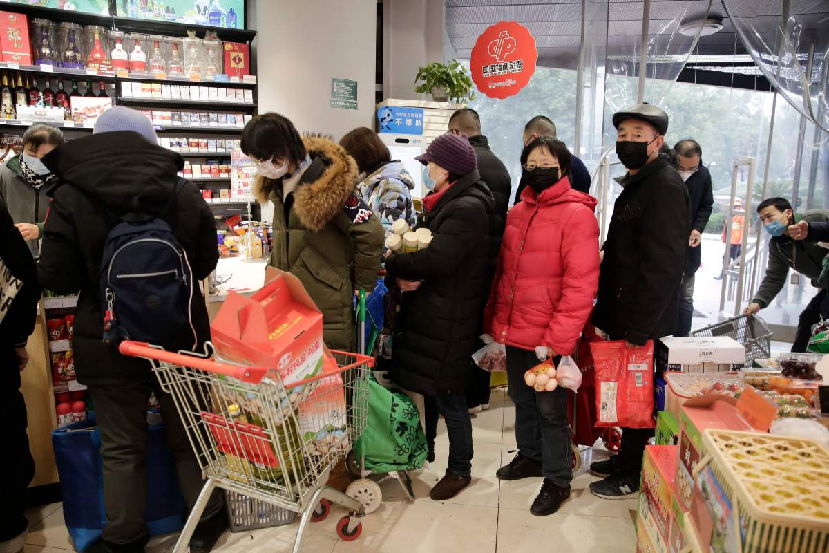 Residents queue up to buy groceries at a market as food prices soar due to the coronavirus outbreak in Wuhan City, Hubei Province, China, 23 January 2020.