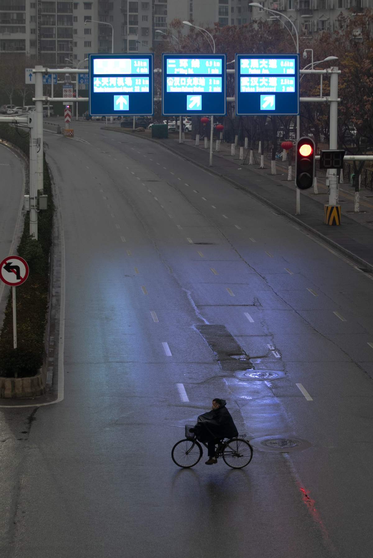 A cyclist crosses an empty street in Wuhan City, Hubei Province, China, 23 January 2020.