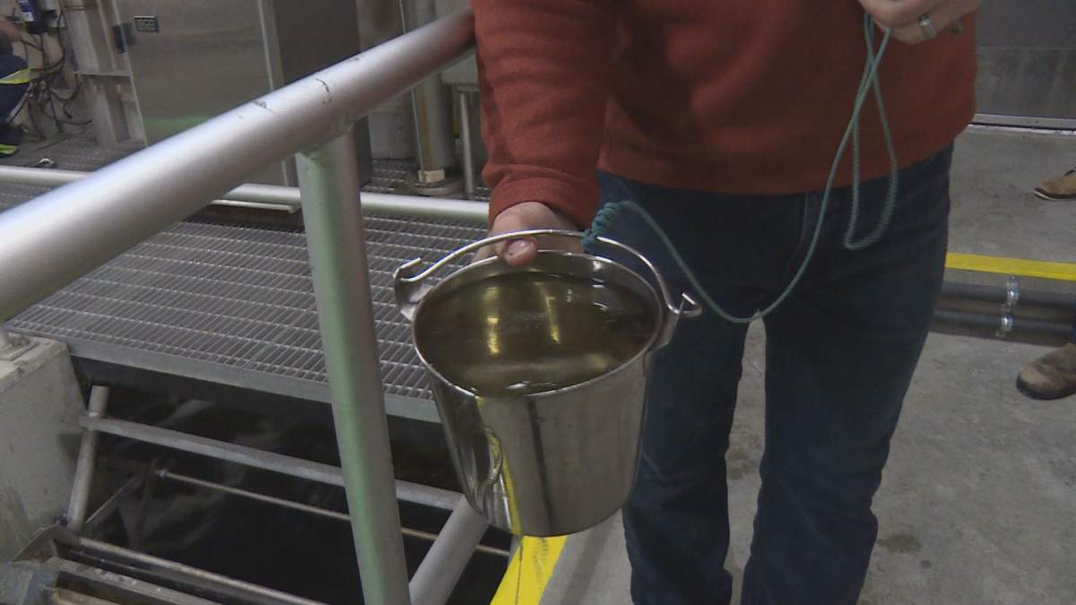 Treatment plant manager Serge Kozin holds up a bucket of water taken from near the outflow of the plant. He said this water is representative of what will be discharged into the lake.