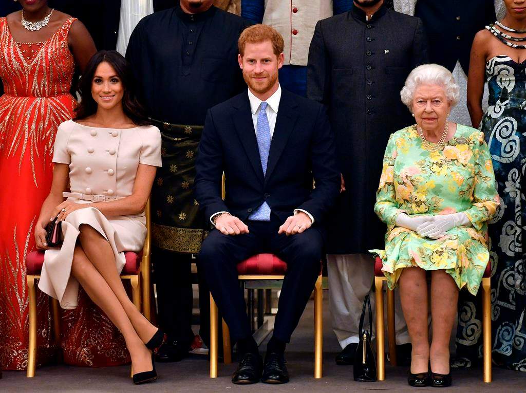 Britain's Queen Elizabeth, Prince Harry and Meghan, Duchess of Sussex pose for a group photo at the Queen's Young Leaders Awards Ceremony at Buckingham Palace in London on Tuesday, June 26, 2018.