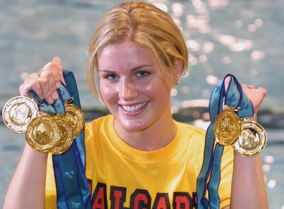 Calgary swimmer Jessica Sloan holds up the six gold medals she won in the Australian Paralympics.