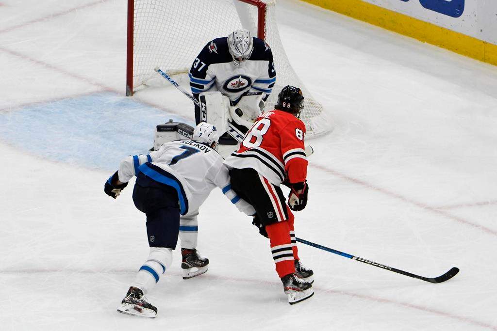 Winnipeg Jets goaltender Connor Hellebuyck (37) makes a save on Chicago Blackhawks right wing Patrick Kane (88) during the second period of an NHL hockey game Sunday, Jan. 19, 2020, in Chicago. (AP Photo/David Banks).