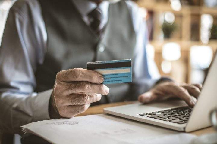Senior businessman using laptop to check credit card .  