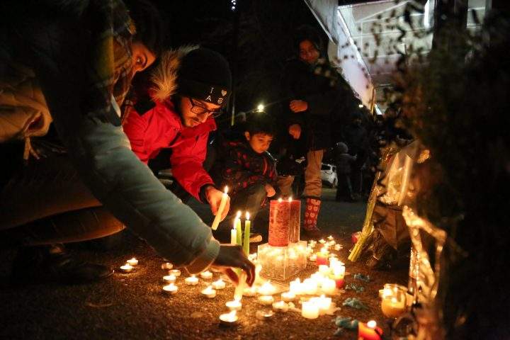 Mourners light candles and place flowers as they attend a vigil for the victims of a plane crash in Iran, outside Amir Bakery on Lonsdale ave. in North Vancouver, B.C., Canada on Jan. 8, 2020. 