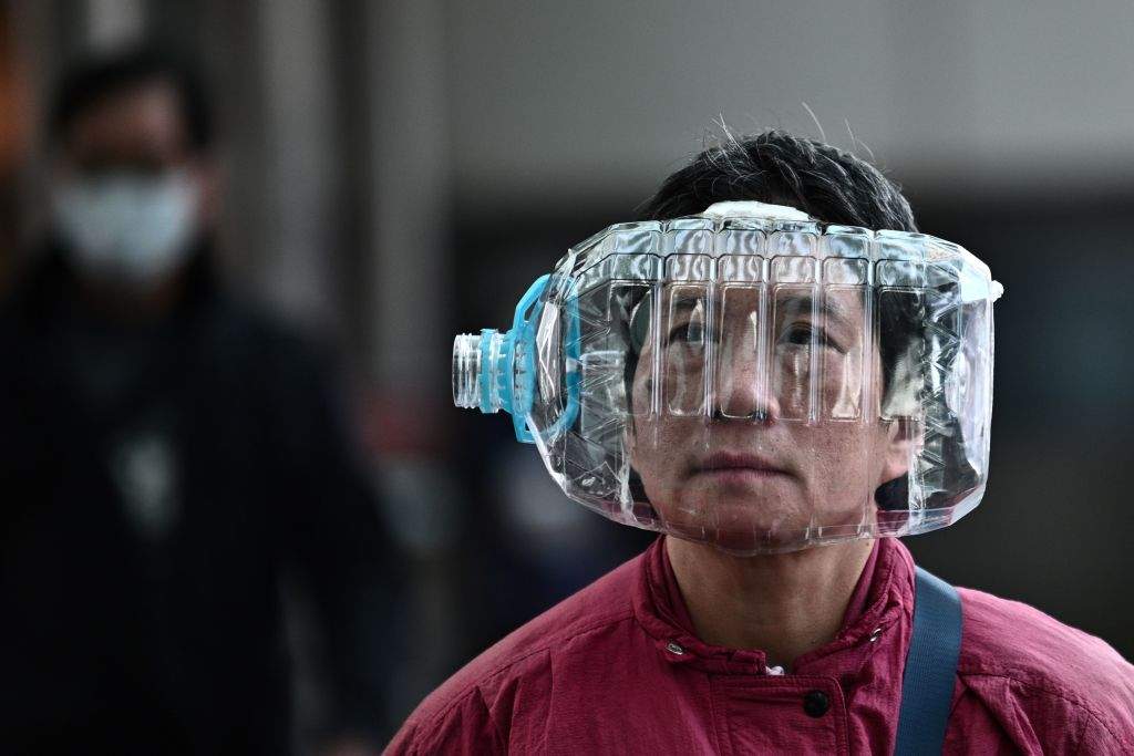 A person wears a plastic water bottle with a cutout to cover their face, as they walk on a footbridge in Hong Kong on Jan. 31, 2020, as a preventive measure following a virus outbreak which began in the Chinese city of Wuhan.