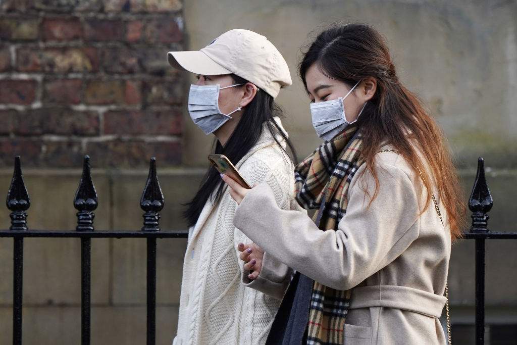 Two women wearing face masks walk through the city centre near the Royal Victoria Infirmary where two patients who have tested positive for the new coronavirus are being treated by specialist medical workers on Jan. 31, 2020 in Newcastle upon Tyne, England.