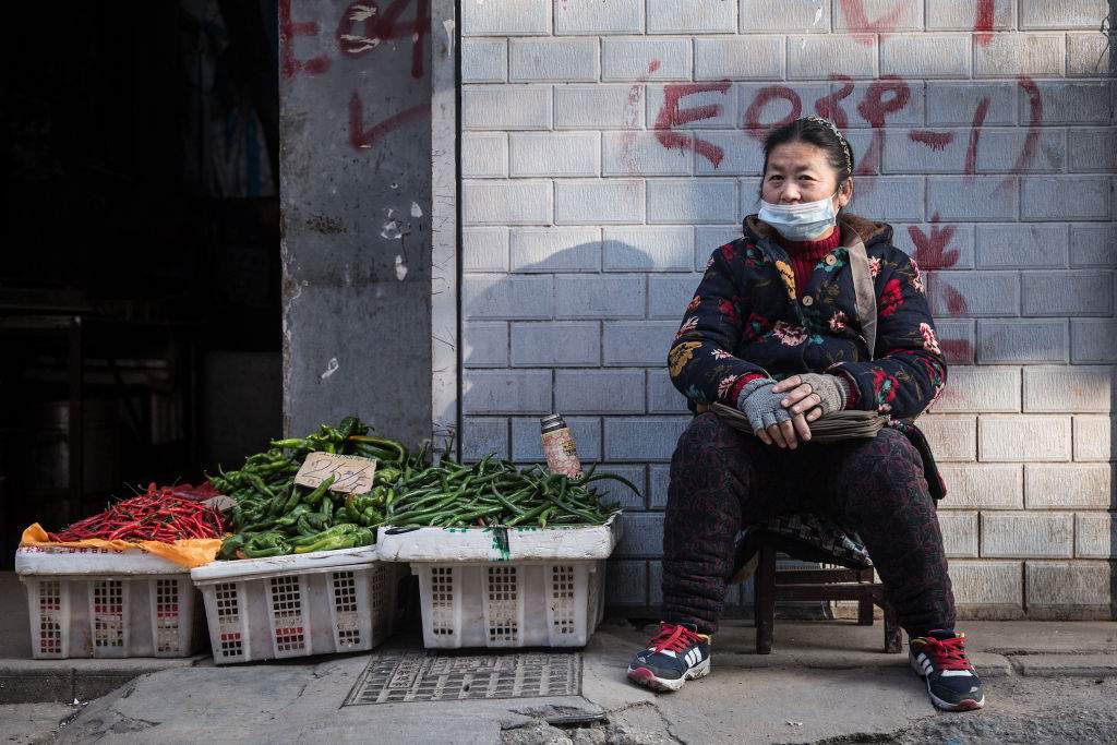 A vegetable vendor wears a protective mask in an alley on Jan. 31, 2020 in Wuhan, China.