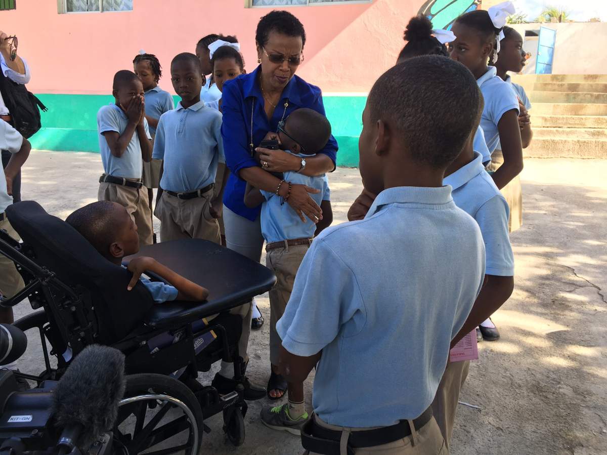 Gladys Thomas, president and director of the Foundation for the Children of Haiti, embraces a boy at Hope Home.