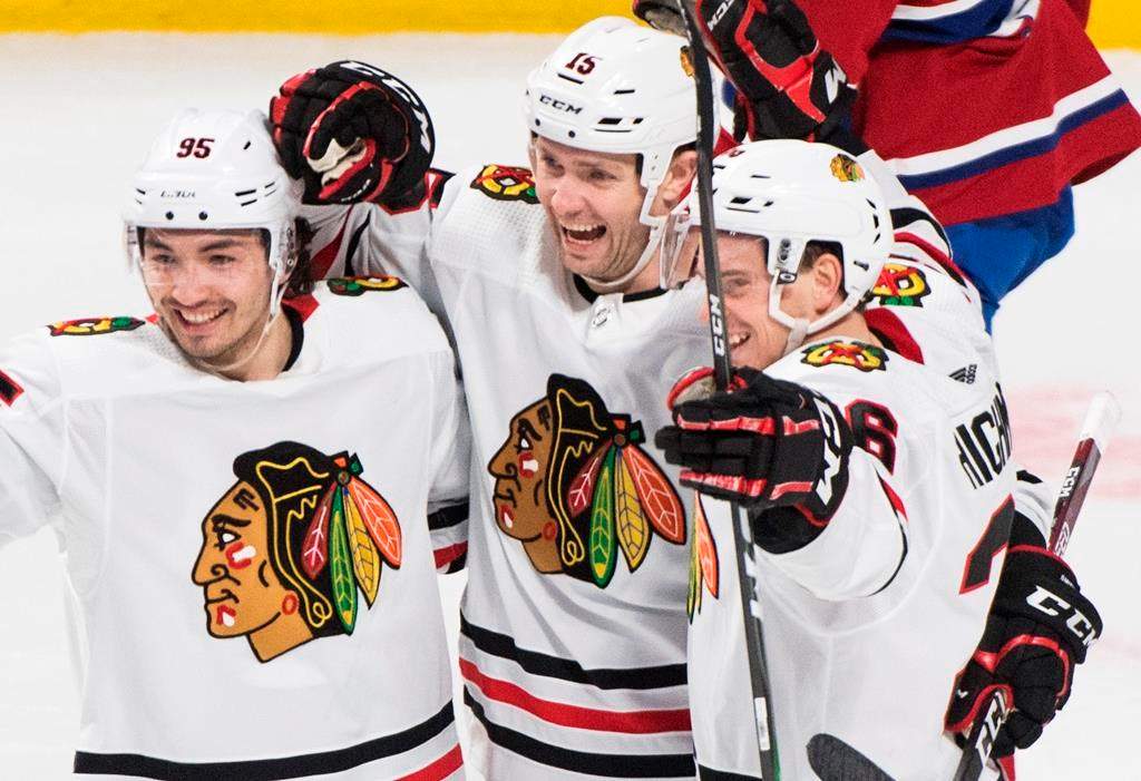 Chicago Blackhawks' Zack Smith (15) celebrates with teammates Matthew Highmore, right, and Dylan Sikura (95) after scoring against the Montreal Canadiens during first period NHL hockey action in Montreal, Wednesday, Jan. 15, 2020.