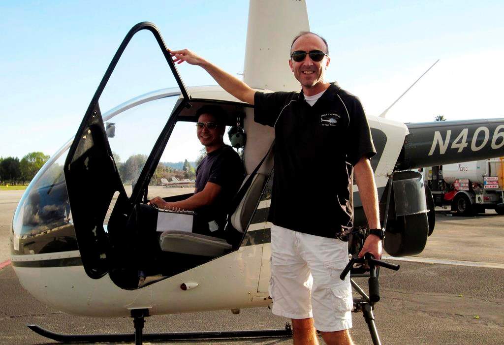 This undated photo provided by Group 3 Aviation shows helicopter pilot Ara Zobayan standing outside a helicopter, at a location not provided. Zobayan was at the controls of the helicopter that crashed in Southern California Sunday, Jan. 26, 2020, killing all nine aboard including former Lakers star Kobe Bryant. The other person inside is unidentified. (Group 3 Aviation via AP)