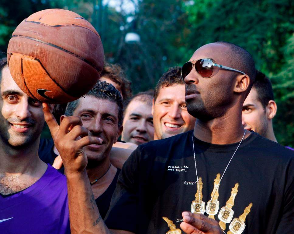 FILE - In this Sept. 28, 2011, file photo, U.S. basketball star Kobe Bryant plays with a ball during a sponsor's appearance in Milan, Italy. In Europe where Bryant grew up, the retired NBA star is being remembered for his "Italian qualities." Italian basketball federation president Giovanni Petrucci tells The Associated Press that Bryant is "particularly important to us because he knew Italy so well, having lived in several cities here. He had a lot of Italian qualities." (AP Photo/Luca Bruno, File).